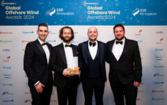 Picture of 4 people in black tie holding up an award